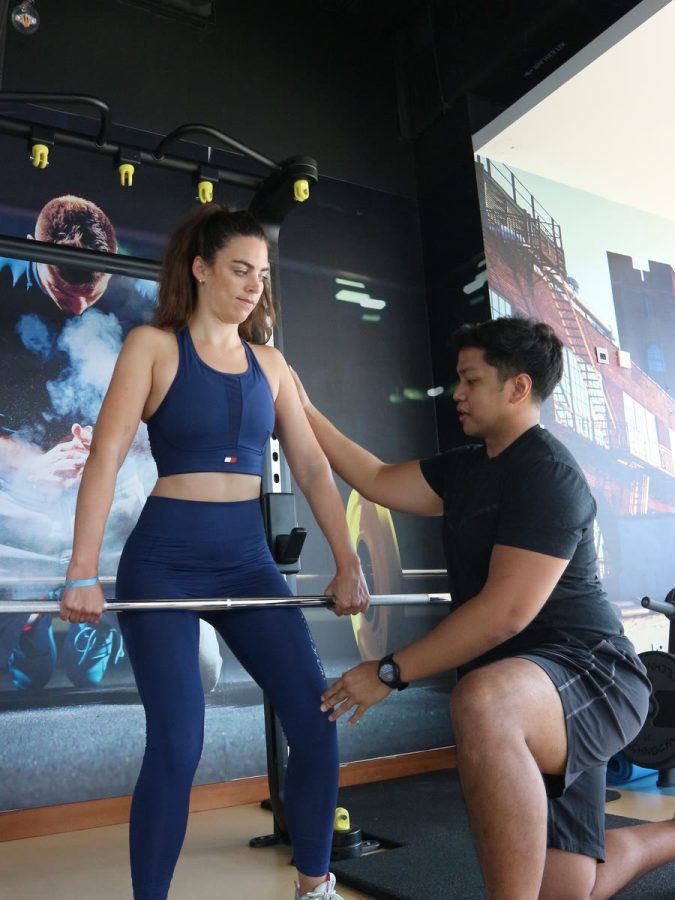 An ATHLI coach cueing a member through a barbell set-up
